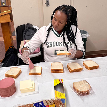 YALI fellow at All Saints Church making sandwiches.