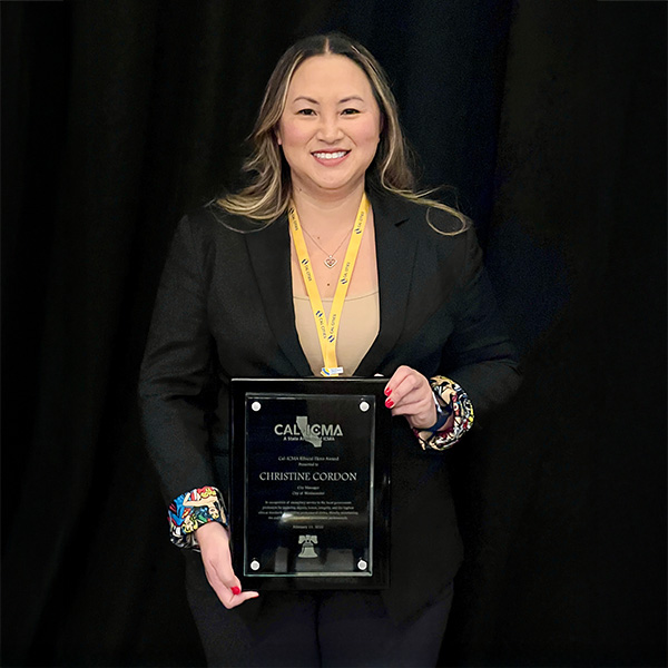 A person holding a Cal-ICMA Ethics Hero Award plaque at an awards ceremony.